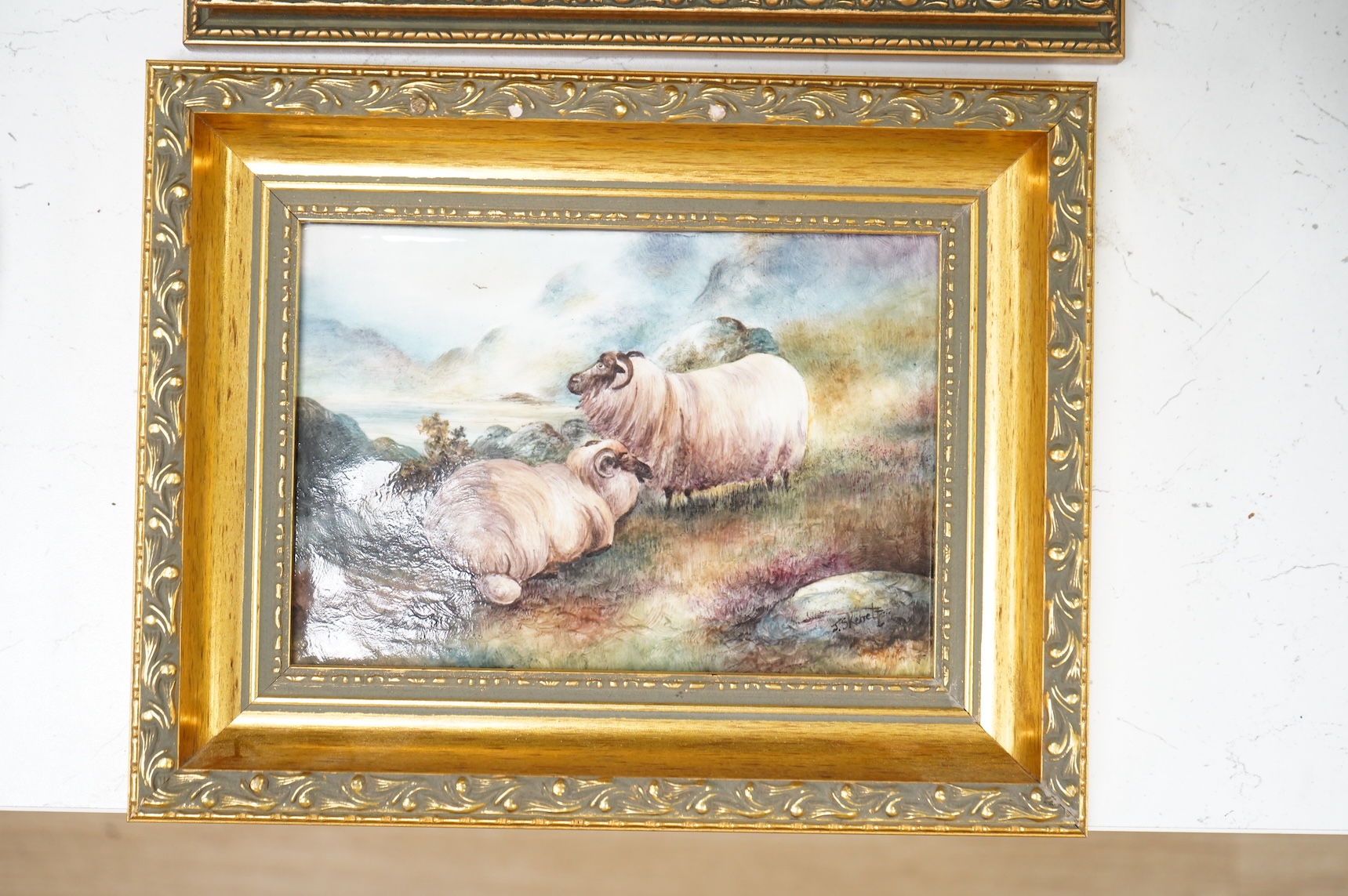 Four porcelain framed plaques, 19th and 20th century hand painted with highland landscapes and figures, two by James Skerrett, gilt framed, largest 21 x 26cm overall